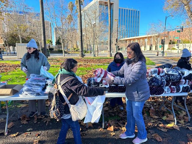 Volunteers handing out blankets on a clear cold morning