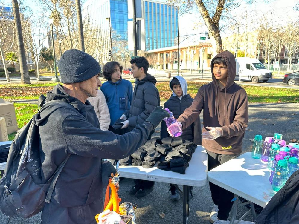 Teenage volunteers handing out water bottles and socks at the park